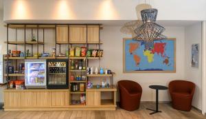 a bar with a refrigerator and two chairs in a room at Aparthotel Adagio Muenchen City in Munich