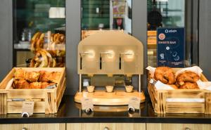 a bakery with a bread machine and baskets of pastries at Aparthotel Adagio Muenchen City in Munich