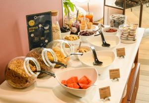 a buffet with bowls of food on a table at Aparthotel Adagio Muenchen City in Munich