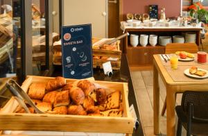 a tray of bread and pastries on a table at Aparthotel Adagio Muenchen City in Munich