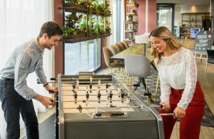 a man and a woman playing a game of chess at Aparthotel Adagio Muenchen City in Munich