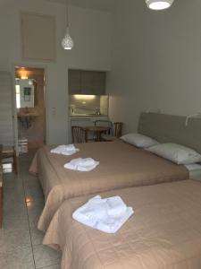 two beds with towels on them in a room at Romantika in Platis Gialos