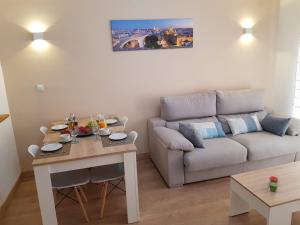 uma sala de estar com uma mesa e um sofá em Apartamento Flor de Azahar em Sevilha