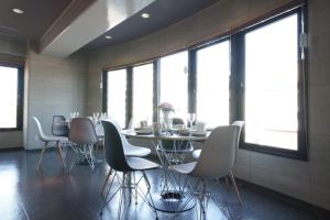 a dining room with a table and chairs and windows at Airstar Fukuoka Airport x Sakono building in Fukuoka