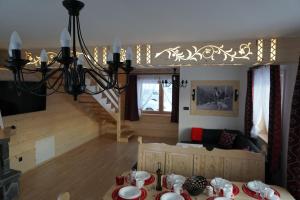 a dining room with a table and a chandelier at Domek u Matusa in Biały Dunajec