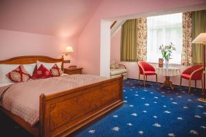 a hotel room with a bed and a table and chairs at Hotel Rezydencja in Karpacz