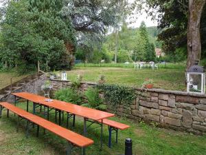 two benches sitting next to a stone wall at Bed en breakfast le Chateau in Lubine