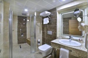 a bathroom with a toilet and a sink and a shower at New Marathon Hotel in Elazığ