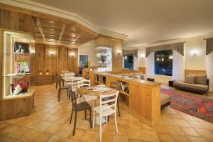 a living room with tables and chairs and a kitchen at Residence Club Ponte Di Legno in Ponte di Legno