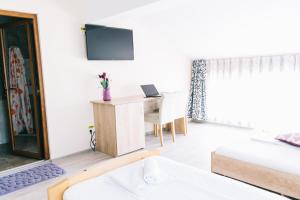 a living room with a desk and a bed at La Tusi Lovrin in Lovrin
