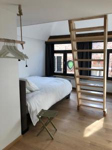 een slaapkamer met een bed, een ladder en een stoel bij B&B Calis in Brugge