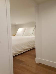 - une chambre avec un lit blanc et du parquet dans l'établissement Loft Luxe Réformé, à Marseille