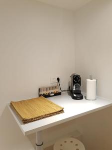 Elle comprend un comptoir blanc avec un grille-pain et une cafetière. dans l'établissement Loft Luxe Réformé, à Marseille