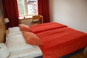 a bedroom with a bed with a red blanket on it at Ruka Chalets 1201 in Ruka