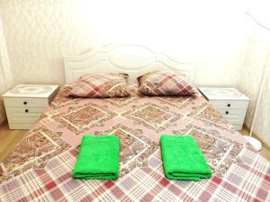 1 dormitorio con 1 cama con toallas verdes en Apartment "Bounty", en Yoshkar-Ola