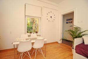 uma sala de jantar branca com uma mesa e cadeiras em Garden Town em Zagreb