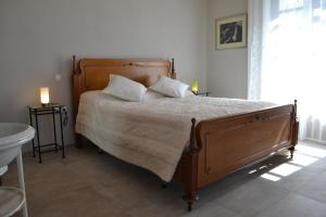 a bedroom with a large wooden bed with pillows at La Cascina dei Banditi in Costigliole dʼAsti