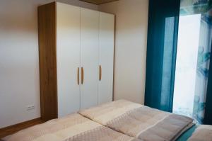a bedroom with a bed and a cabinet at Hengnau 46, Ferienwohnung Stiefel in Wasserburg am Bodensee
