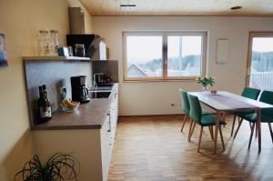 eine Küche und ein Esszimmer mit Tisch und Stühlen in der Unterkunft Hengnau 46, Ferienwohnung Stiefel in Wasserburg