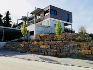 ein Haus auf einer steinernen Stützmauer in der Unterkunft Hengnau 46, Ferienwohnung Stiefel in Wasserburg