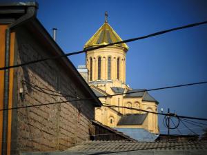 a church steeple with a cross on top of a building at Paparti in Tbilisi City