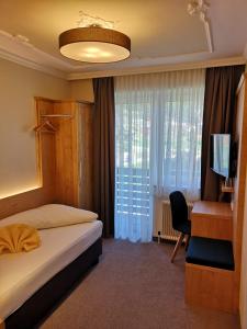 a hotel room with a bed and a desk and a television at Hotel Thier in Mönichkirchen