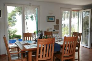 a dining room with a wooden table and chairs at Deluxe Villa Sirena on the beach with Pool in Supetar