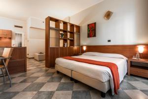 1 dormitorio con 1 cama grande y cocina en Residence 2Gi, en Milán