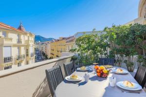 a table with eggs and fruit on a balcony at Palais l'Escurial AP4069 by Riviera Holiday Homes in Nice