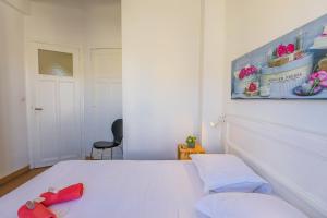 ein Schlafzimmer mit einem weißen Bett und einem schwarzen Stuhl in der Unterkunft Palais l'Escurial AP4069 by Riviera Holiday Homes in Nizza