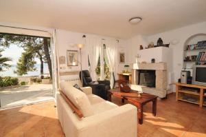 a living room with a couch and a fireplace at Deluxe Villa Sirena on the beach with Pool in Supetar