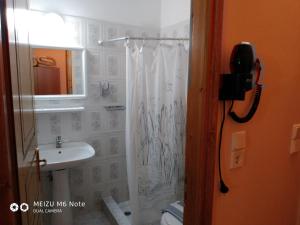 a bathroom with a shower curtain and a sink at Hotel Spiridoula in Kleidoniá