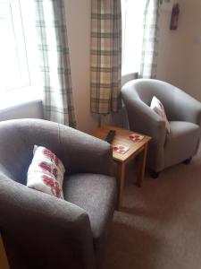 a living room with a couch and a chair and a table at Berry House Bed & Breakfast in Littlehampton