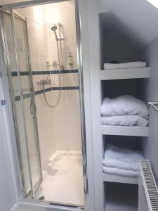 a bathroom with a shower and some white towels at Berry House Bed & Breakfast in Littlehampton