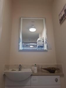 a bathroom with a mirror and a sink at Berry House Bed & Breakfast in Littlehampton