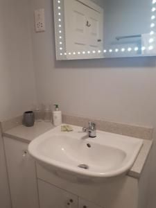a bathroom with a white sink and a mirror at Berry House Bed & Breakfast in Littlehampton