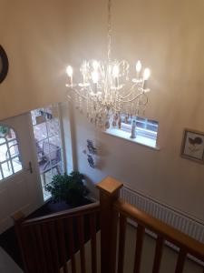 a chandelier hanging from the ceiling in a staircase at Berry House Bed & Breakfast in Littlehampton