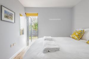 a white bedroom with a large bed and a window at The Garden House, Free Parking, Central in St. Andrews