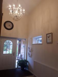 una lámpara de araña colgada sobre una puerta en una habitación en Berry House Bed & Breakfast, en Littlehampton