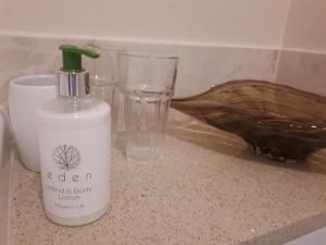 a bottle of cleaner sitting on a counter next to a glass at Berry House Bed & Breakfast in Littlehampton