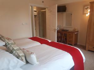 a bedroom with a bed with a red and white blanket at Berry House Bed & Breakfast in Littlehampton