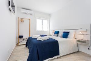 a bedroom with a large bed with blue sheets at Sleep Inn Lagos - Rooms in Lagos