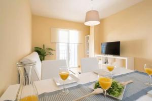 ein Esszimmer mit einem Tisch und Gläsern Orangensaft in der Unterkunft Shiny Lud Family Apartment in Málaga