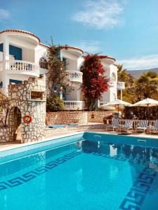 a villa with a swimming pool in front of a building at Dolphin Apartments 1 in Parga