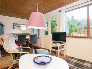 a living room with a table and a tv at 4 person holiday home in Gedser in Gedser