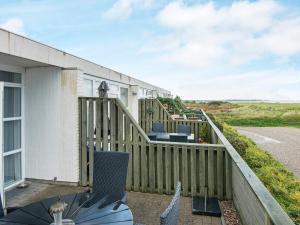 a balcony with a wooden fence and a table and chairs at 4 person holiday home in R m in Rømø Kirkeby