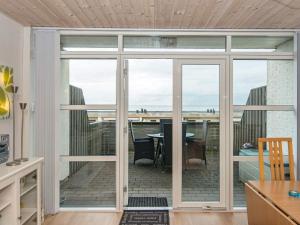 una puerta corredera de cristal que conduce a un patio con mesa en 4 person holiday home in R m, en Rømø Kirkeby