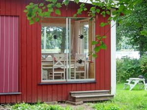 a red house with a sliding glass door with a table at 4 star holiday home in SOLLENTUNA in Sollentuna