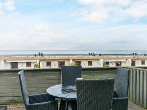 a table and chairs on a balcony with a building at 4 person holiday home in R m in Rømø Kirkeby