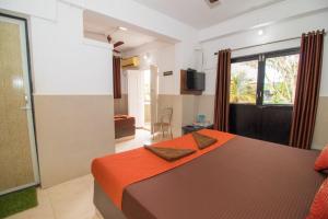 a bedroom with a large bed with an orange blanket at Travo Suites Panjim in Panaji
